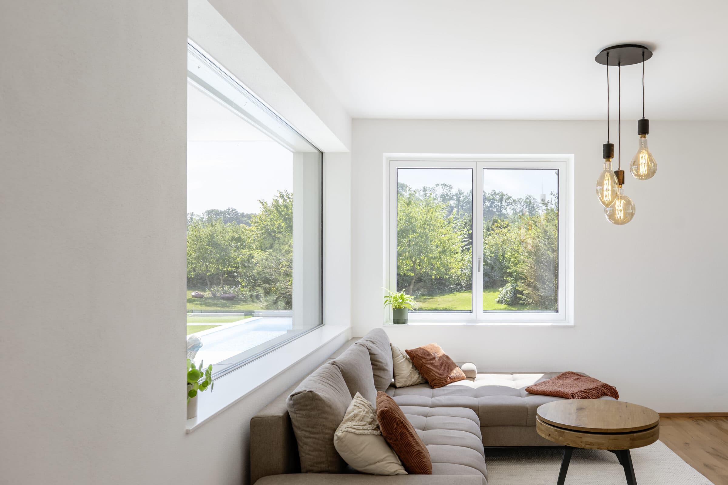 Séjour avec fenêtre PVC/aluminium Internorm ouverte sur le jardin, photo Internorm
