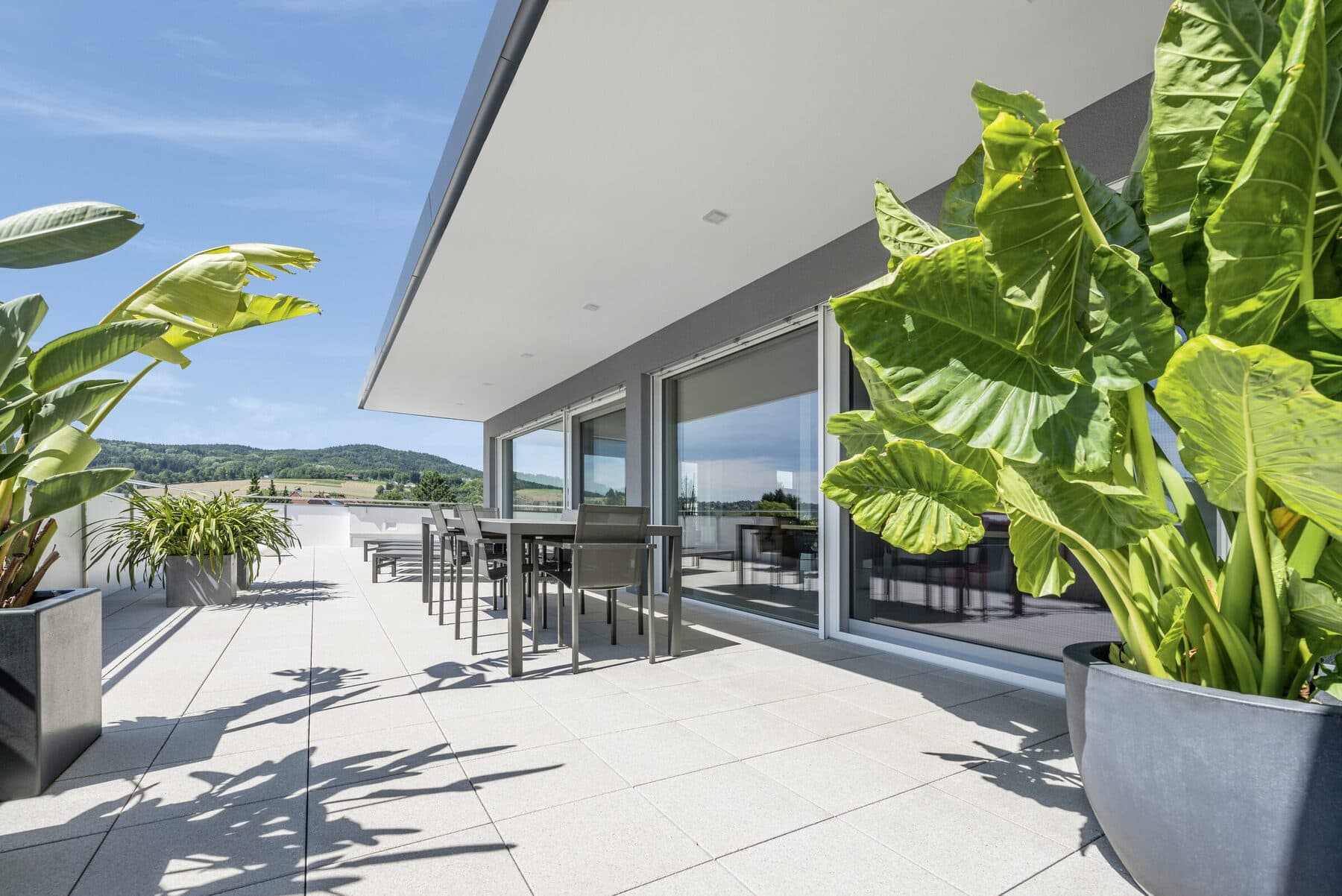 Terrasse ensoleillée bordée de grandes baies vitrées coulissantes Internorm, photo Internorm