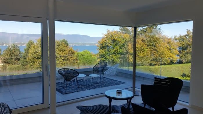 Terrasse couverte et baies vitrées d’une villa Minergie à Hermance